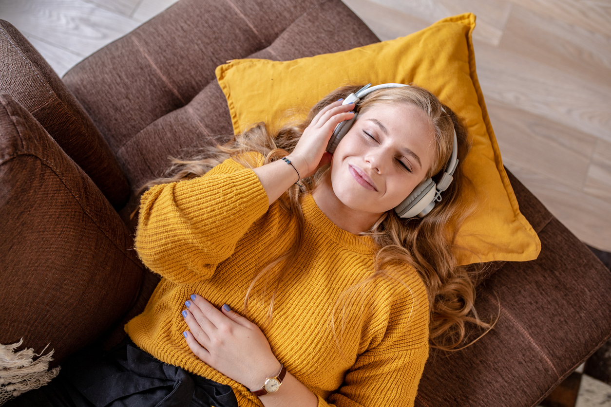 Photo of young woman listening to music with headphones